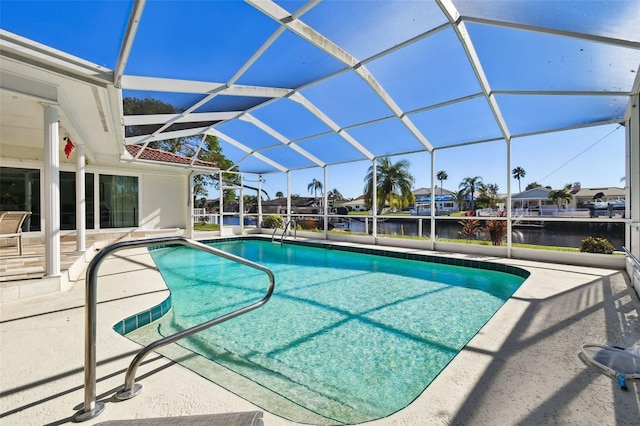 view of swimming pool with glass enclosure, a patio area, and a water view