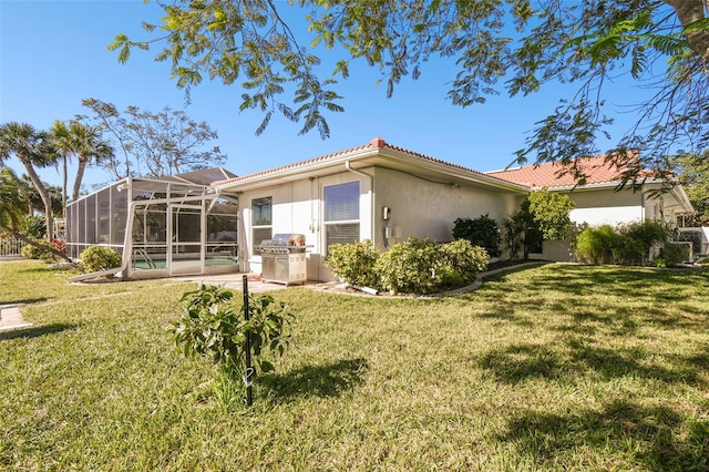 back of house with a lanai, a swimming pool, and a yard