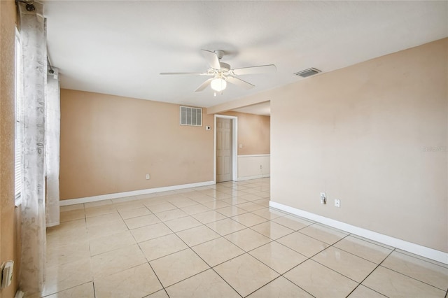 tiled empty room featuring ceiling fan