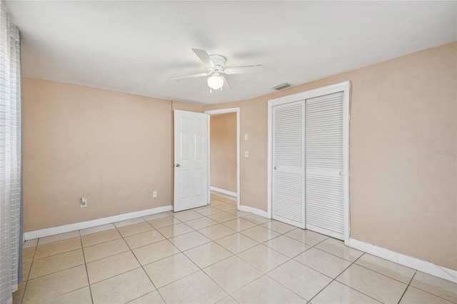 unfurnished bedroom featuring light tile patterned floors, a closet, and ceiling fan