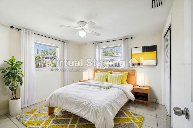 tiled bedroom featuring a closet, multiple windows, and ceiling fan