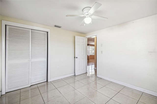 unfurnished bedroom with ceiling fan, light tile patterned floors, and a closet