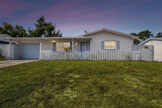 ranch-style house featuring a yard and a garage