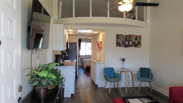 interior space featuring sink, a towering ceiling, and dark hardwood / wood-style floors