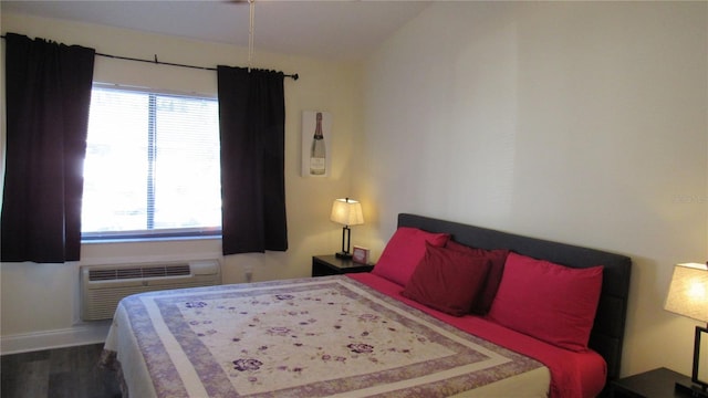 bedroom featuring wood-type flooring, vaulted ceiling, multiple windows, and an AC wall unit