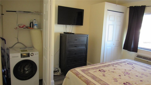 bedroom with wood-type flooring, an AC wall unit, and washer / clothes dryer