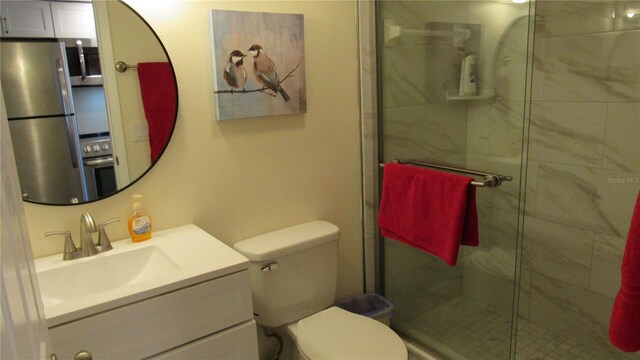 bathroom with vanity, toilet, and a shower with door