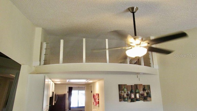 room details with ceiling fan and a textured ceiling