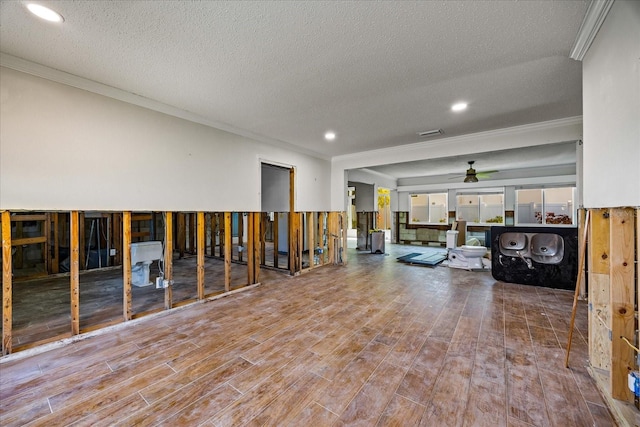 misc room with hardwood / wood-style floors, ceiling fan, ornamental molding, and a textured ceiling