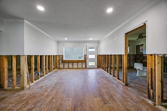 unfurnished room featuring hardwood / wood-style flooring, ceiling fan, crown molding, and a textured ceiling