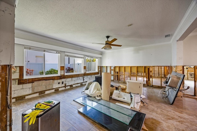 rec room featuring a textured ceiling, ceiling fan, crown molding, wooden walls, and hardwood / wood-style flooring