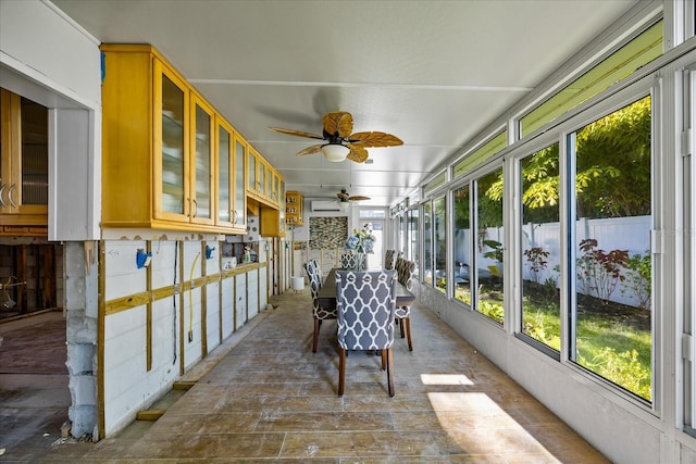 sunroom featuring a wall mounted AC and plenty of natural light