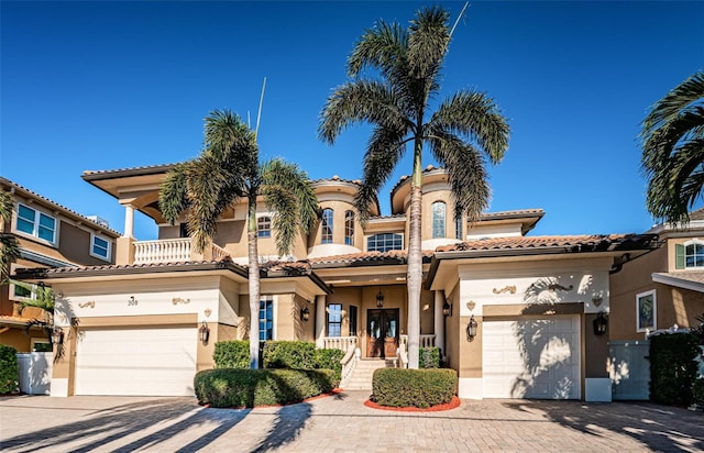 mediterranean / spanish-style home featuring a garage and a balcony