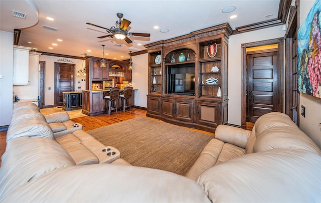 living room featuring light wood-type flooring, ceiling fan, and ornamental molding