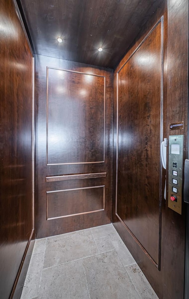 interior details featuring elevator and wooden walls