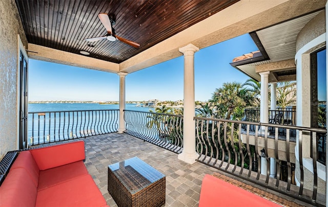 balcony featuring ceiling fan and a water view