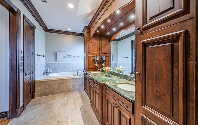 bathroom featuring vanity, tiled bath, and ornamental molding