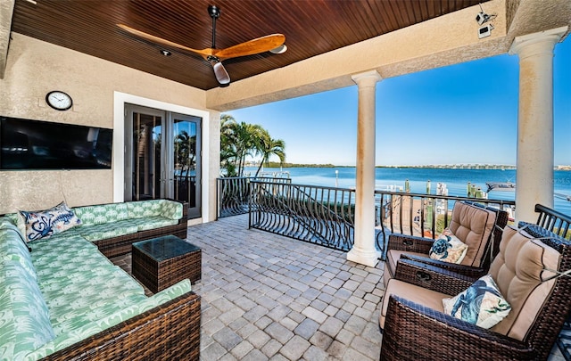 view of patio / terrace featuring an outdoor living space, a water view, ceiling fan, and a balcony