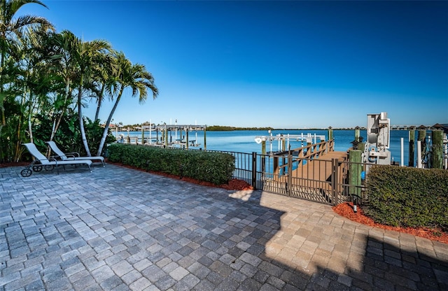 view of patio with a water view and a boat dock