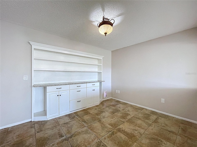 interior space with built in shelves and a textured ceiling