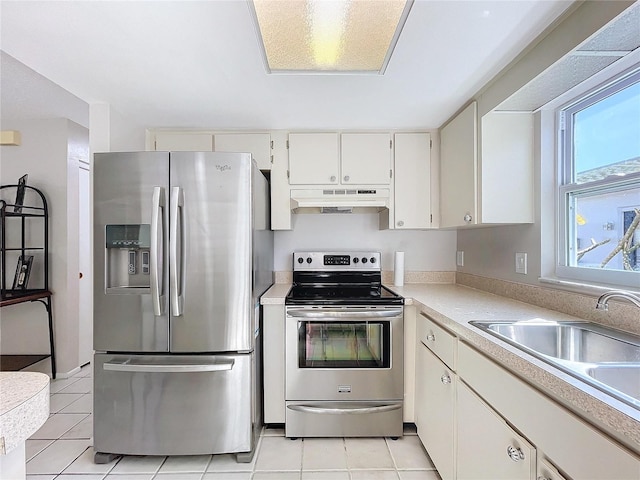 kitchen featuring white cabinets, light tile patterned floors, stainless steel appliances, and sink