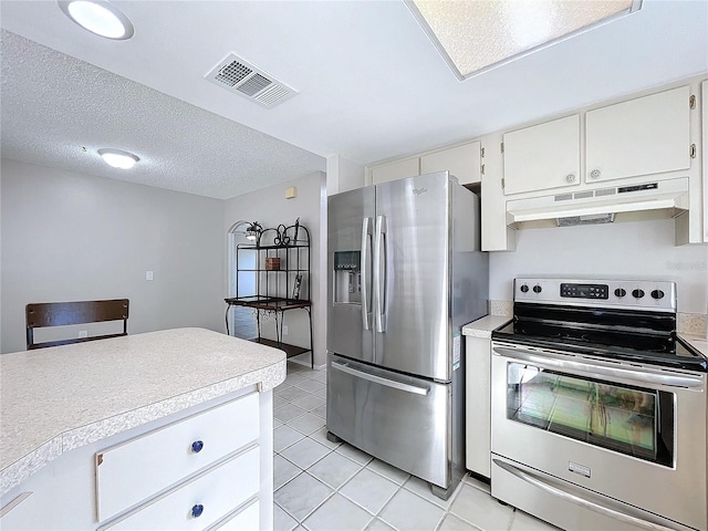 kitchen featuring a textured ceiling, white cabinets, stainless steel appliances, and light tile patterned floors