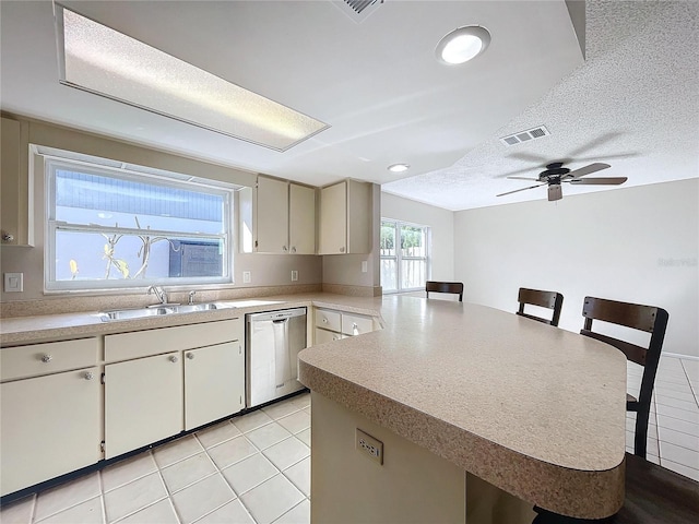 kitchen with kitchen peninsula, a kitchen breakfast bar, a textured ceiling, sink, and dishwasher