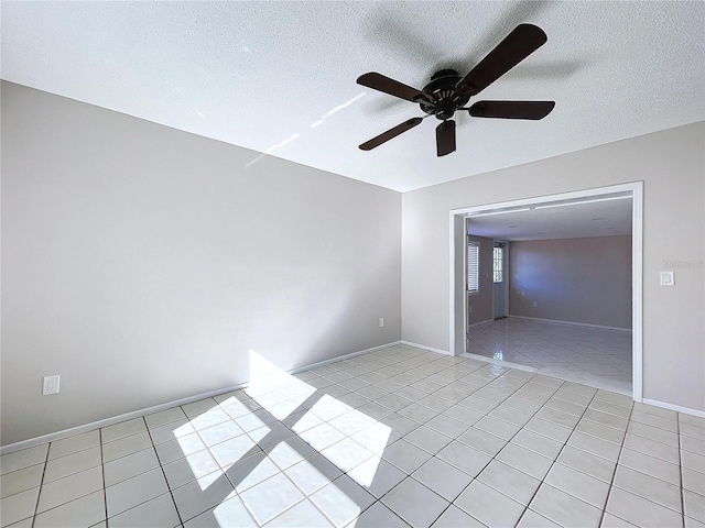 tiled spare room with a textured ceiling and ceiling fan