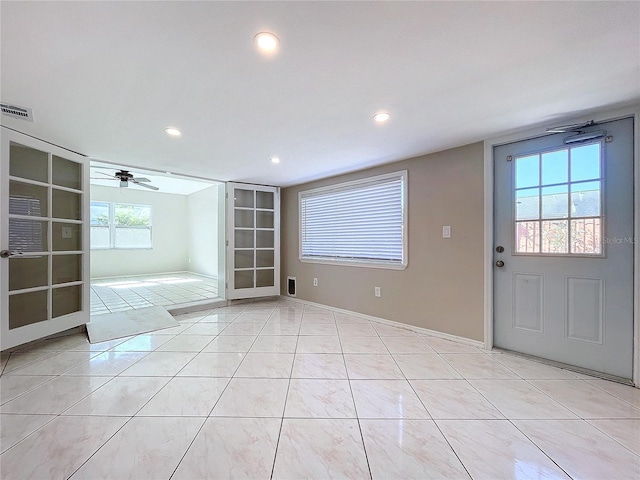 interior space featuring a wealth of natural light, ceiling fan, and light tile patterned floors