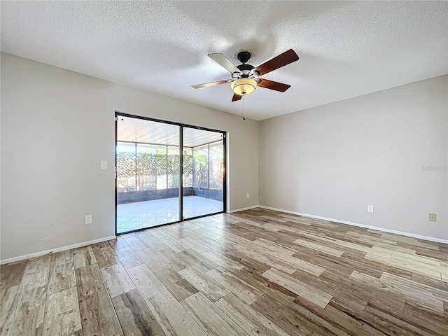 empty room featuring ceiling fan, light hardwood / wood-style flooring, and a textured ceiling