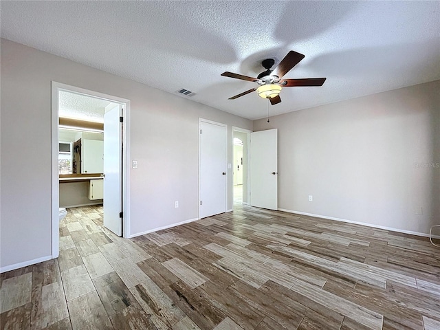 spare room featuring hardwood / wood-style flooring, ceiling fan, and a textured ceiling