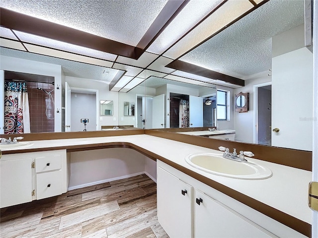 bathroom with hardwood / wood-style flooring, vanity, and a textured ceiling