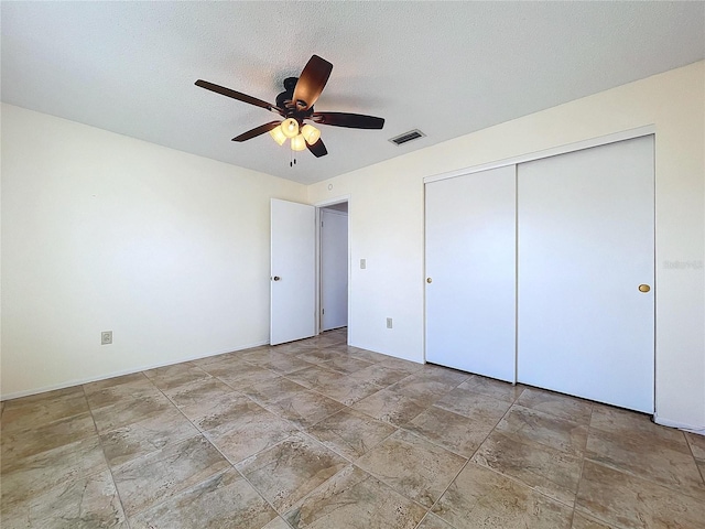 unfurnished bedroom with ceiling fan, a closet, and a textured ceiling