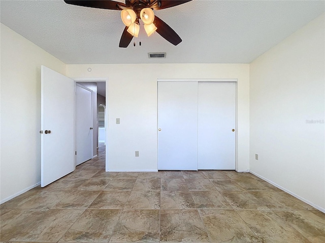 unfurnished bedroom featuring ceiling fan, a closet, and a textured ceiling