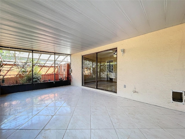 unfurnished sunroom with ceiling fan