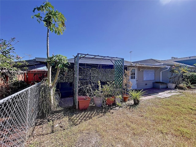 back of property featuring a pergola and a yard