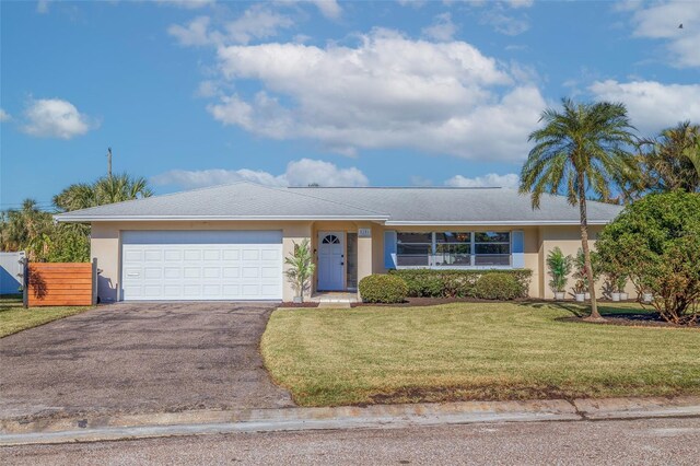 ranch-style house featuring a front yard and a garage