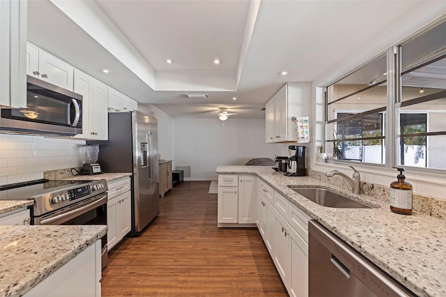 kitchen featuring light stone countertops, sink, dark wood-type flooring, white cabinets, and appliances with stainless steel finishes