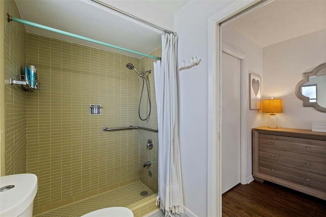 bathroom with toilet, a shower with shower curtain, and hardwood / wood-style flooring