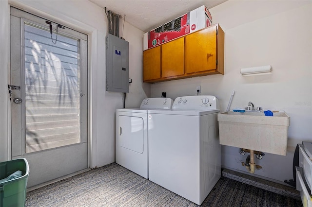 clothes washing area featuring cabinets, electric panel, washer and clothes dryer, and sink