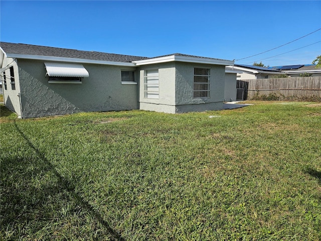 rear view of property with a lawn