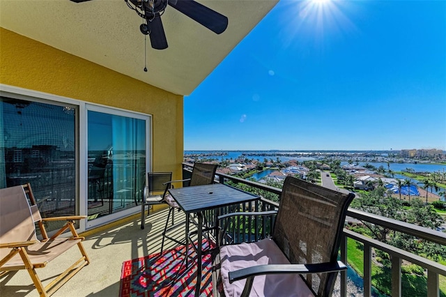 balcony featuring ceiling fan and a water view