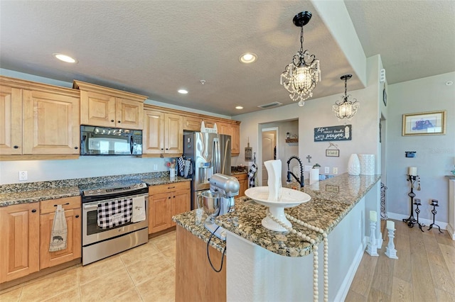 kitchen with a chandelier, a textured ceiling, recessed lighting, light stone countertops, and stainless steel appliances