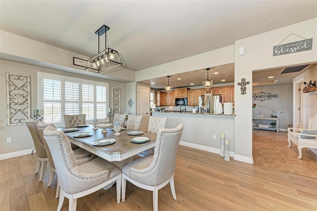 dining room featuring light wood-style flooring, recessed lighting, a chandelier, and baseboards