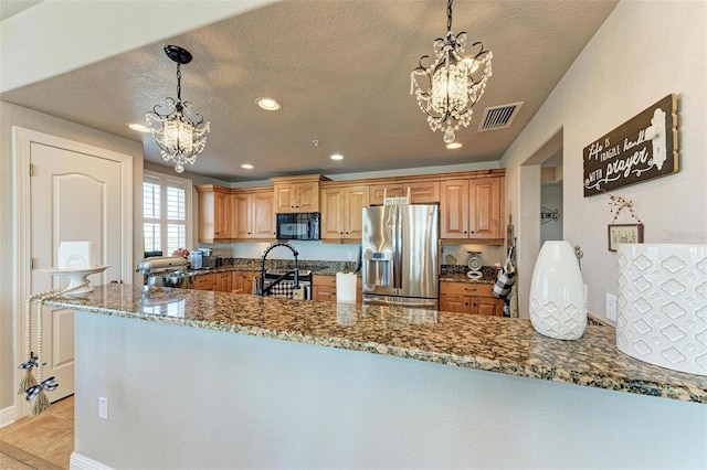 kitchen featuring an inviting chandelier, a textured ceiling, visible vents, dark stone counters, and appliances with stainless steel finishes