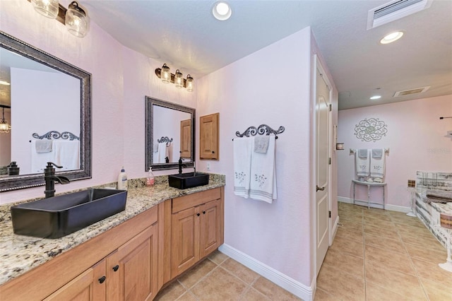 bathroom with a sink, tile patterned flooring, and visible vents