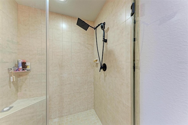 full bath with a shower stall and a textured wall