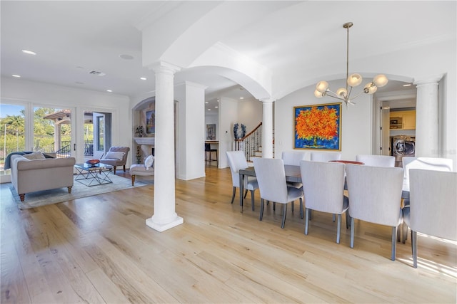 dining area featuring washer / dryer, light hardwood / wood-style floors, and a notable chandelier