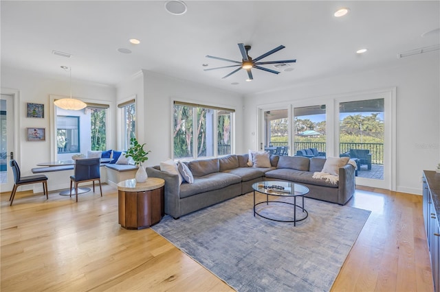 living room featuring ceiling fan, crown molding, and light hardwood / wood-style flooring