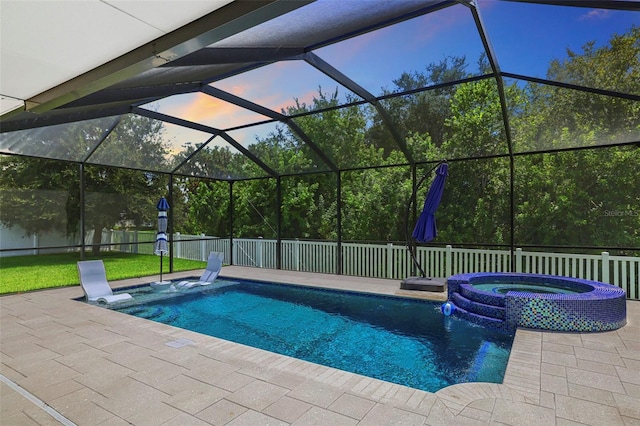 pool at dusk featuring an in ground hot tub, a patio, and a lanai